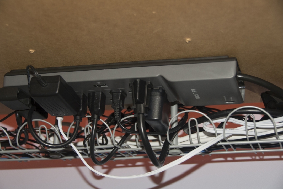 Under desk mounted surge protector with cable management tray with well managed cables
